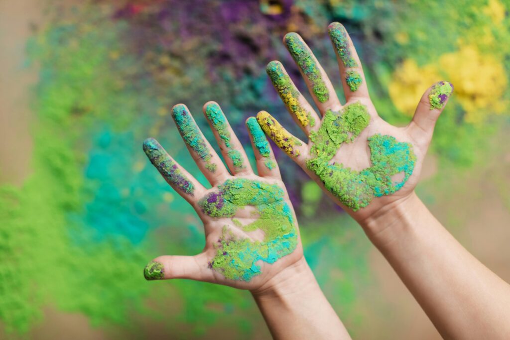 Vibrant hands covered in Holi festival powder, celebrating color and joy.