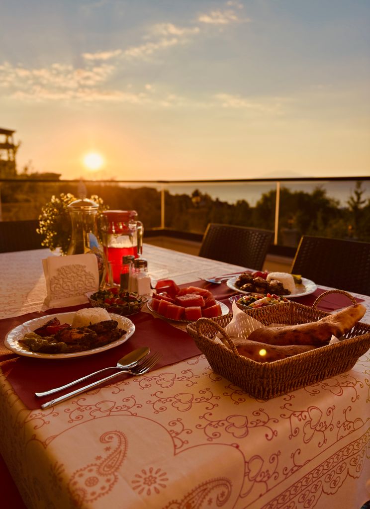 Elegant outdoor dinner setup with traditional dishes at sunset, ideal for food and travel imagery.