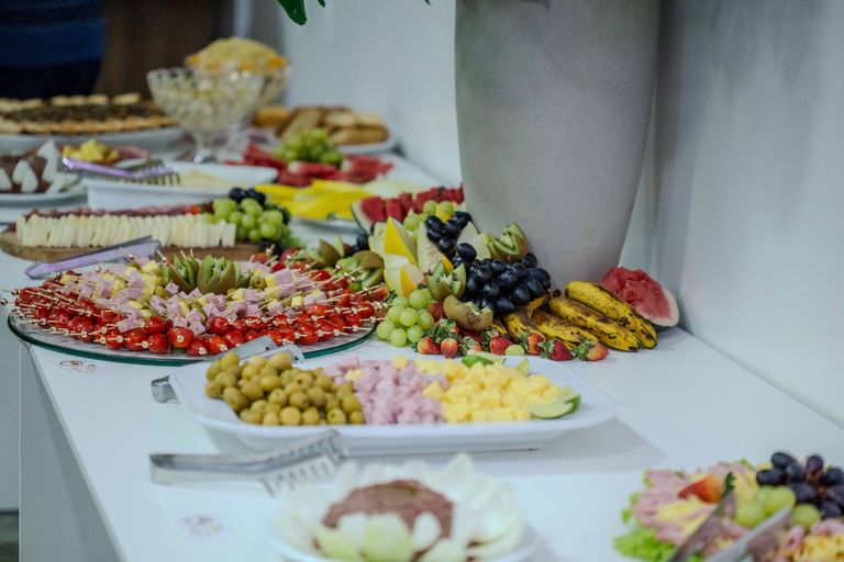Vibrant assortment of fruits and appetizers beautifully arranged on a buffet table indoors.