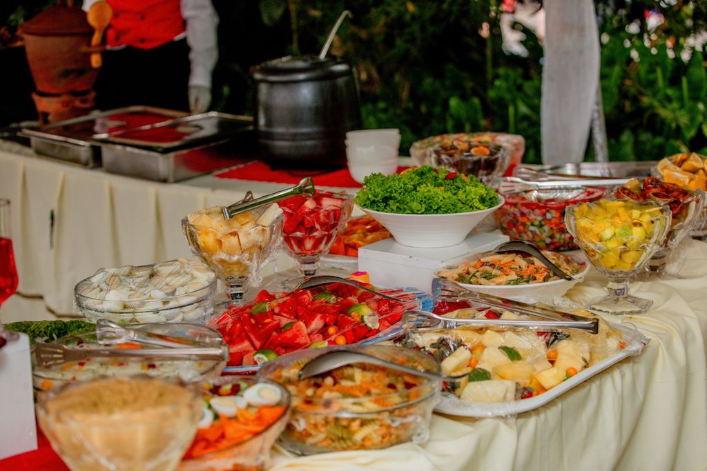 Vibrant display of fresh fruits and salads on a buffet table outdoors.